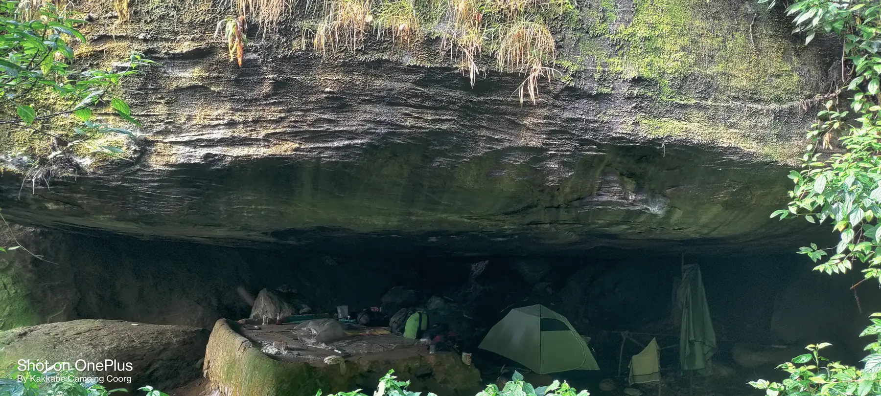 Tents pitched under the overhanging rock of the stone cave